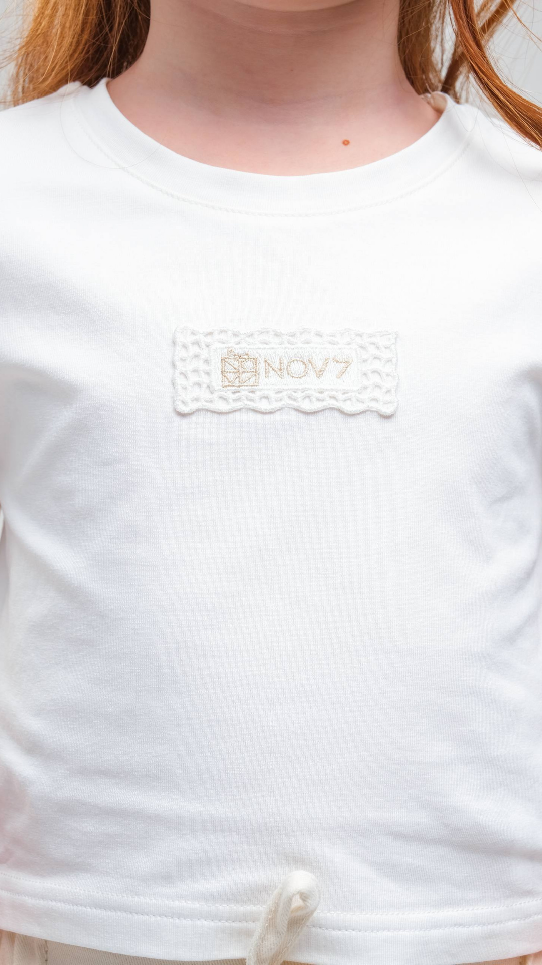 Black NOV7 Signature Soft Tee t-shirt with a relaxed fit, soft fabric, and classic crew neckline, shown on a hanger.