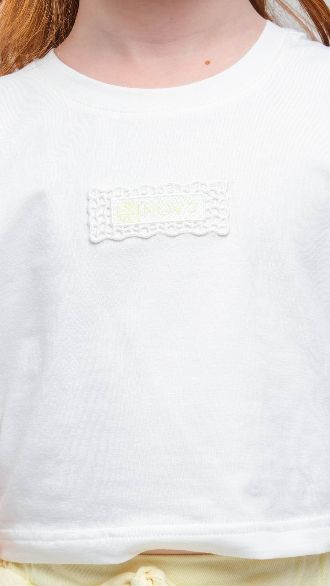 Light gray NOV7 Signature Soft Tee t-shirt displayed on a hanger, showcasing its smooth fabric and casual fit.