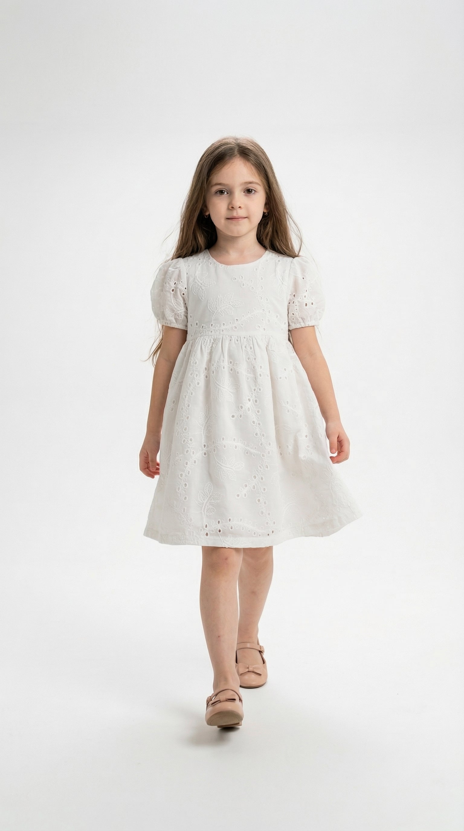 Child wearing a Daisy Light Dress by Kocak Kids, featuring a flowy design with floral patterns and pastel colors.