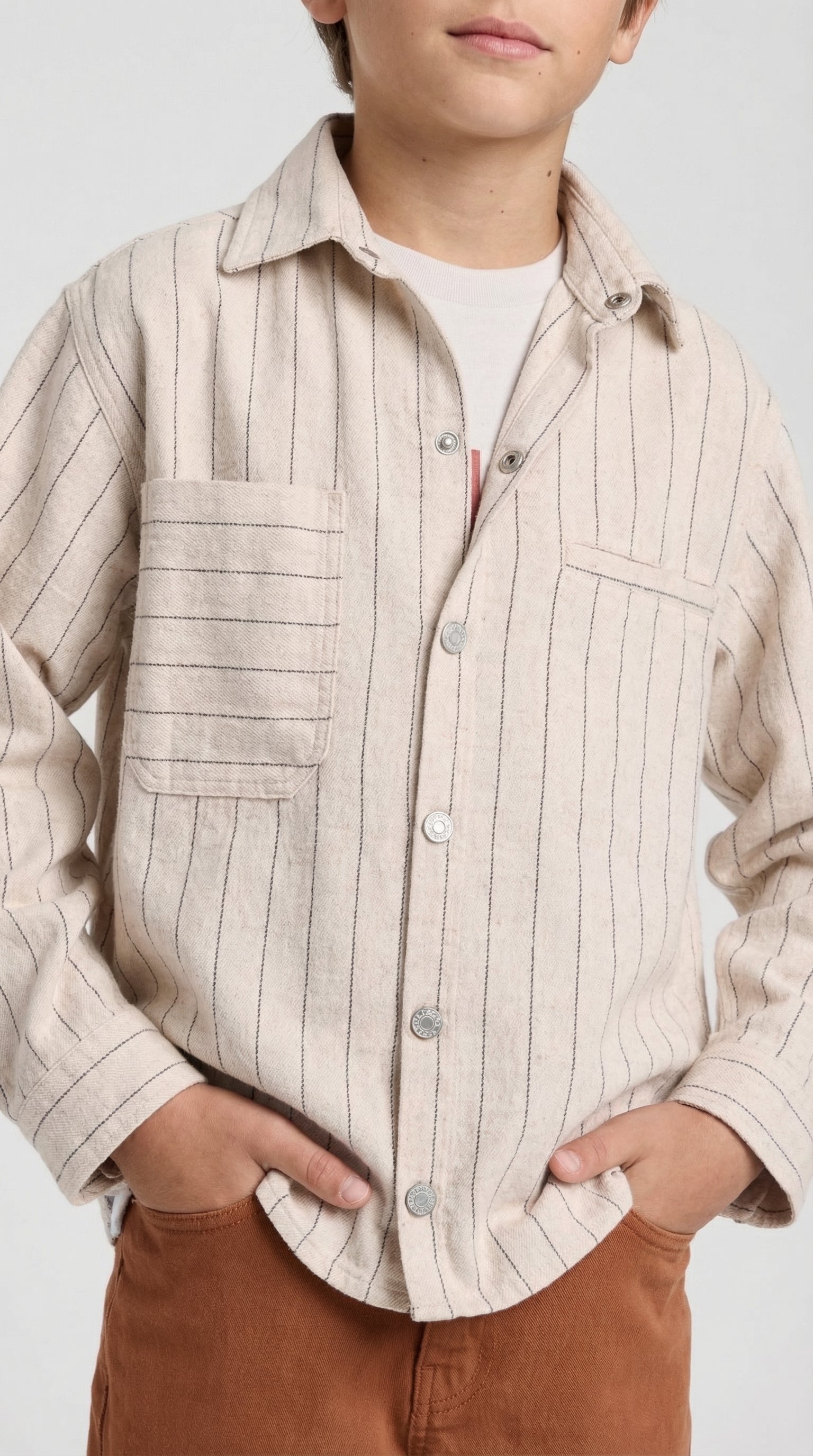 Children's beige pinstripe utility shirt by Escable Kids, featuring a classic collar and button front, shown on a young model.