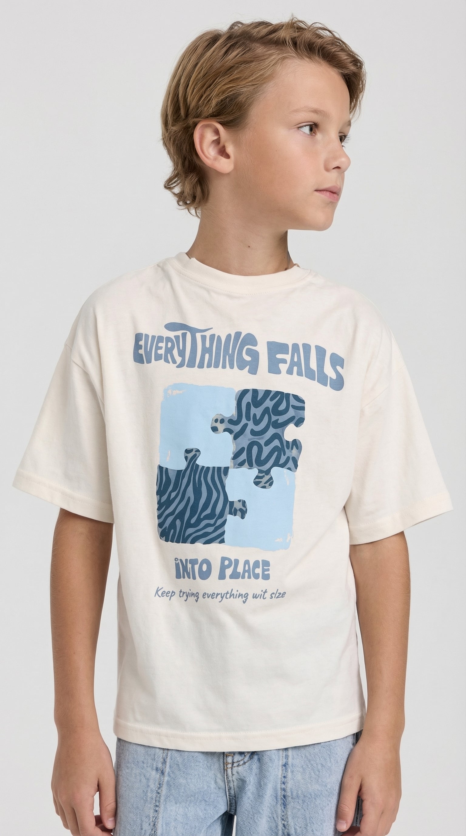 Children's cotton t-shirt with puzzle graphic design by Escable Kids, featuring colorful puzzle pieces on a soft fabric background.