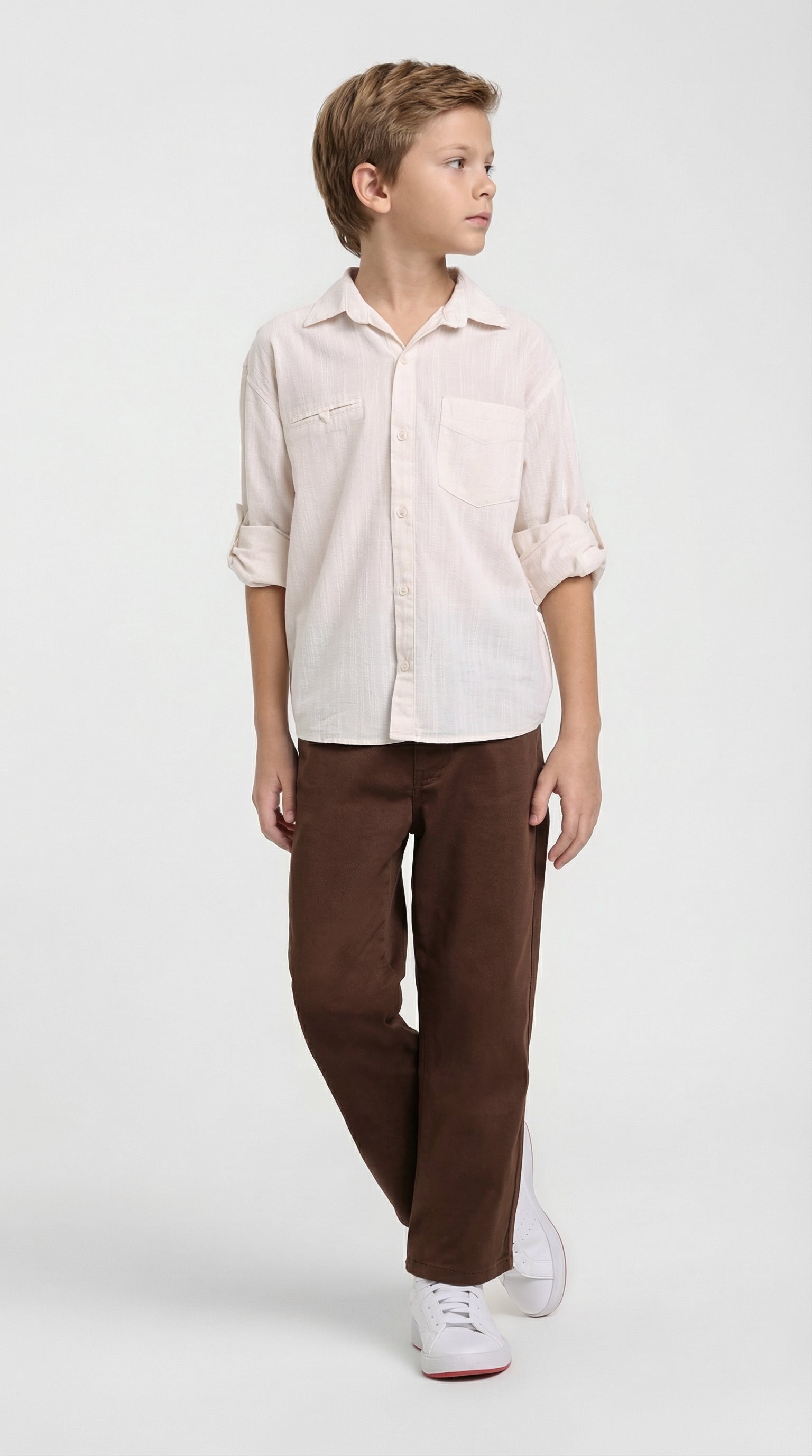 Child wearing a natural linen shirt and brown pants set by Escable Kids, featuring comfortable, casual children's fashion.